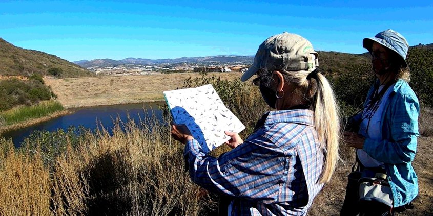 Naturalists Paige DeCino (left) and Karen Merrill survey South Lake Reservoir. Photo: Vallecitos Water District