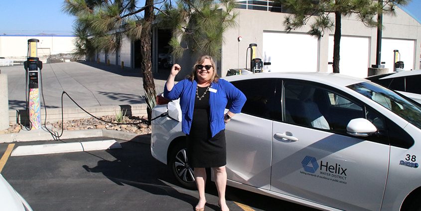 Helix Water District Board President Kathleen Coates Hedberg poses with one of the district's electric Prius service vehicles at a charging station. Photo: Helix Water District Water energy leader
